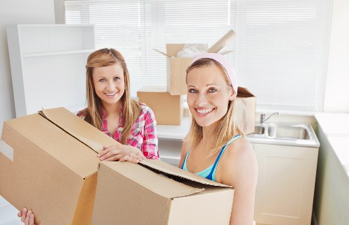 Local movers carrying furniture through a residential building in Swiss Cottage