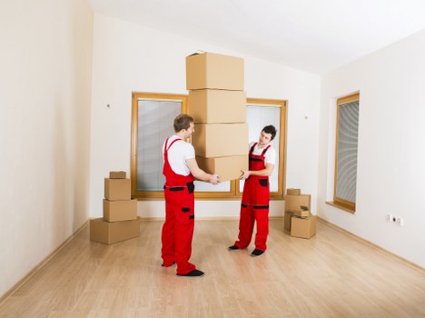 Movers carrying furniture through a residential property in Swiss Cottage